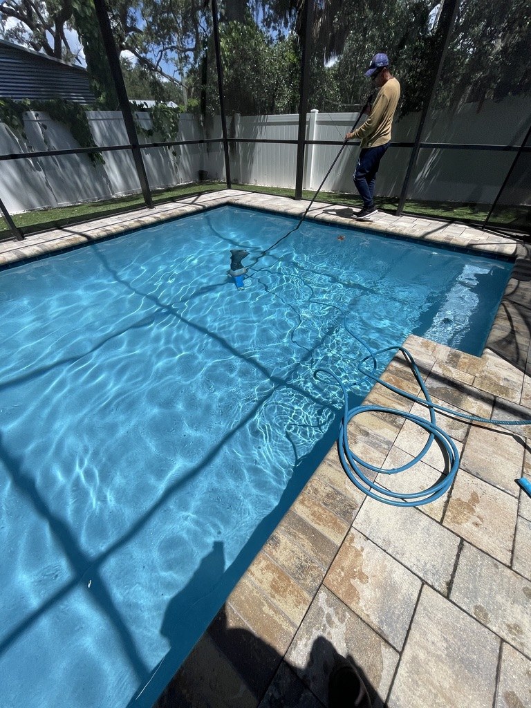 Tampa VIP technician vacuuming a clear residential pool